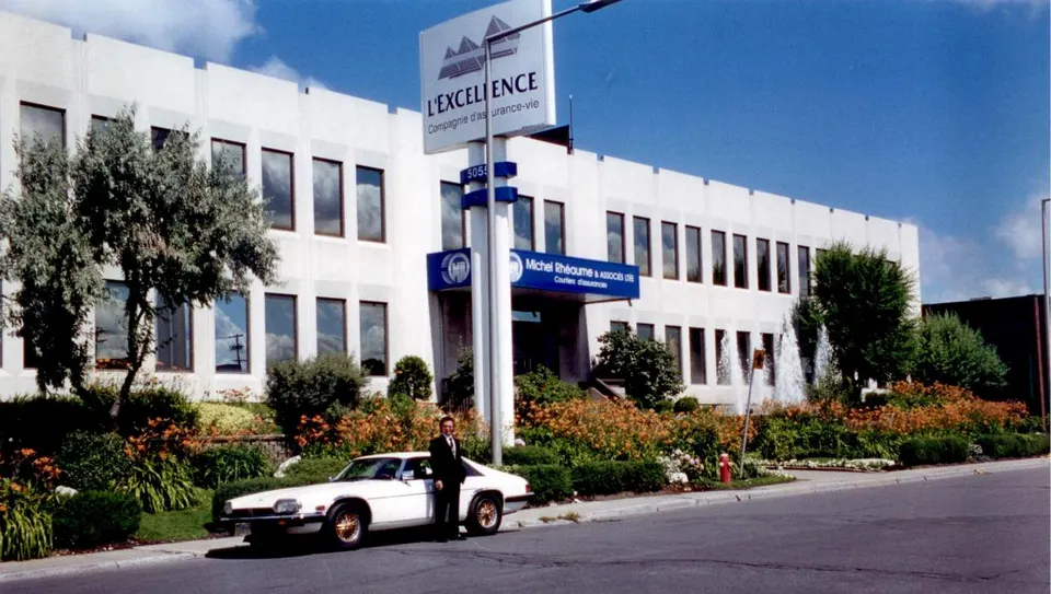Michel Rhéaume Sr. devant le siège social de L'Excellence, dont l'enseigne porte aussi le nom de Michel Rhéaume & Associés ltée